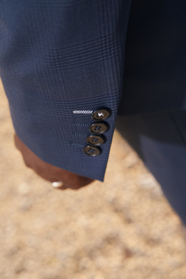 Zoom sur la manche de la veste SUAT couleur marine à carreaux. Elle comporte 4 boutons.
