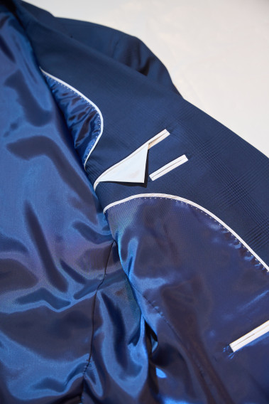 Zoom sur la veste du costume SUAT marine à carreaux. Elle comporte 3 poches d'intérieures.