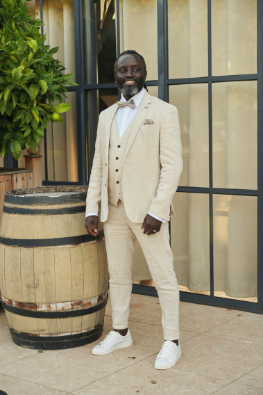 Homme portant la veste TROPICAL beige. Elle comporte une poche poitrine et 2 poches plaquées.