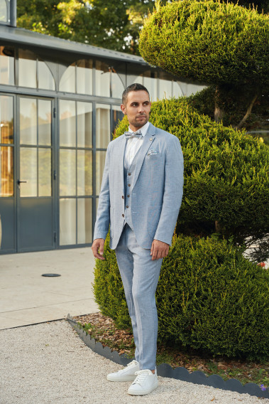 Homme portant la veste TROPICALW bleue. Elle comporte une poche poitrine et 2 poches plaquées.