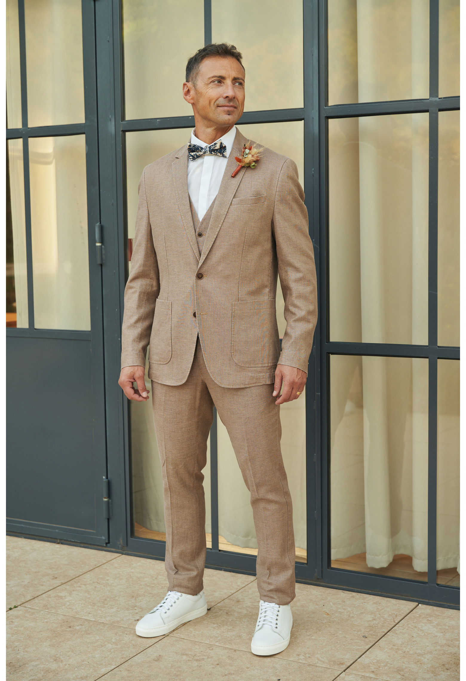 Homme portant la veste TROPICALW brune. Elle comporte une poche poitrine et 2 poches plaquées.