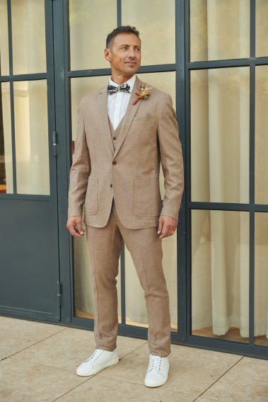 Homme portant la veste TROPICALW brune. Elle comporte une poche poitrine et 2 poches plaquées.