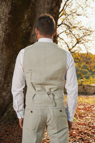 Homme de dos portant le gilet PIANOSA vert avec possibilité de le resserrer.