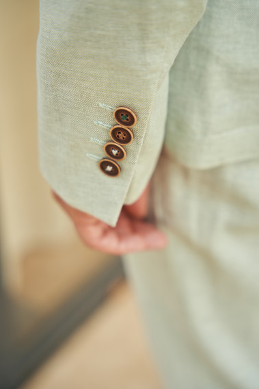 Veste GIORGIOVW vert pastel. Plan zoomé sur la manche avec des boutons marrons foncés.